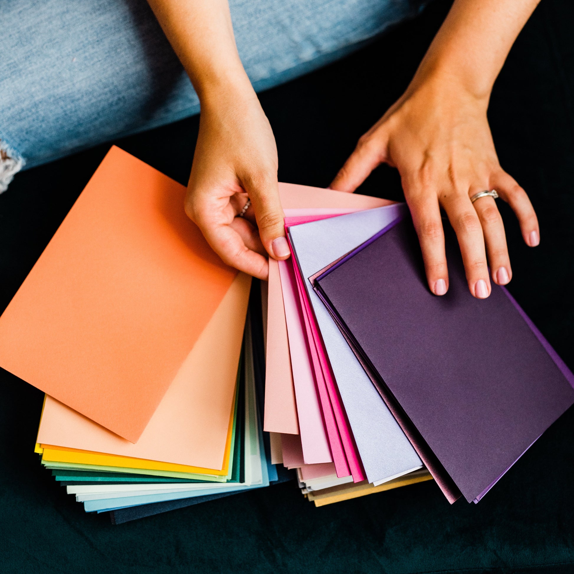 pittsburgh small business owner and artist holding colorful envelopes for wedding invitations