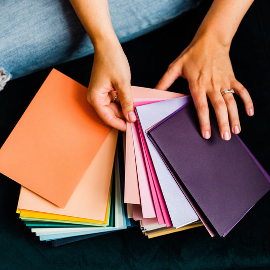 pittsburgh small business owner and artist holding colorful envelopes for wedding invitations