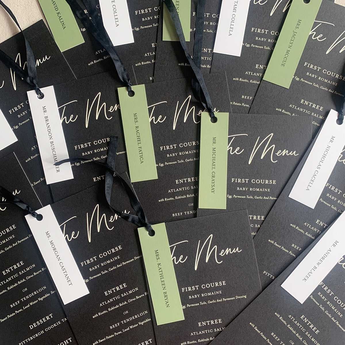 black wedding menus with colorful place cards attached with black silk ribbons